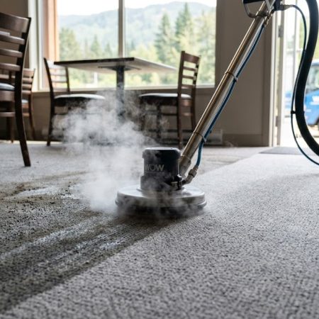 Before and after heavy-duty commercial carpet cleaning, showing a rotating jet tool removing thick grease and deep-set soil from restaurant carpet.